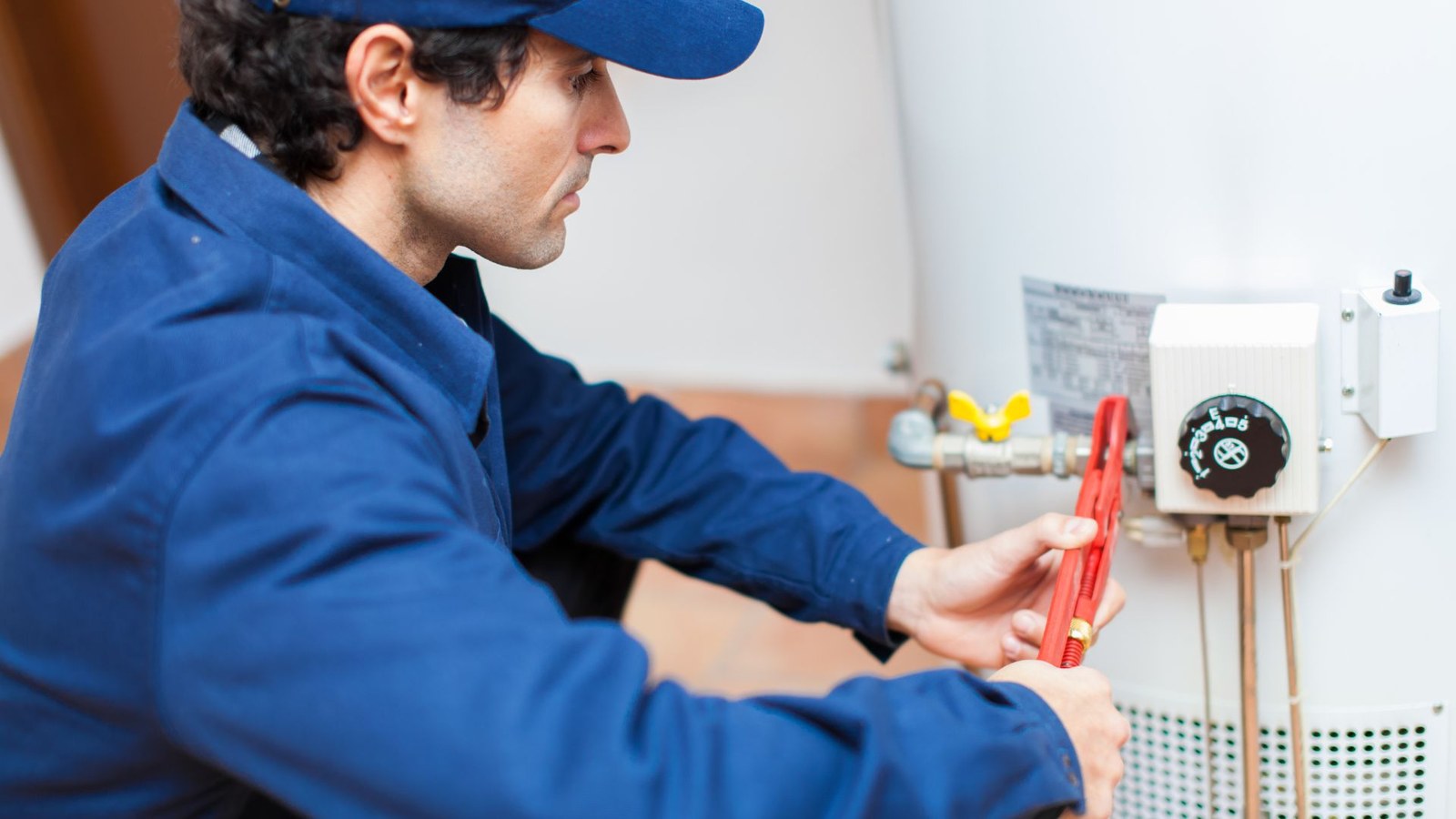 A technician adjusting a newly installed water heater