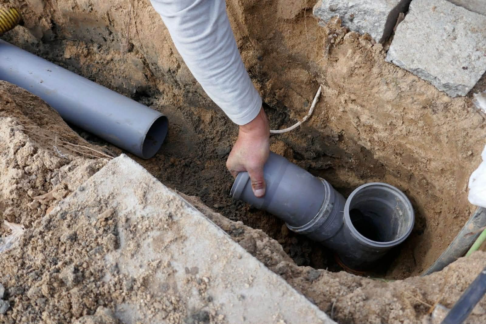 A sewer line being joined in an excavated trench